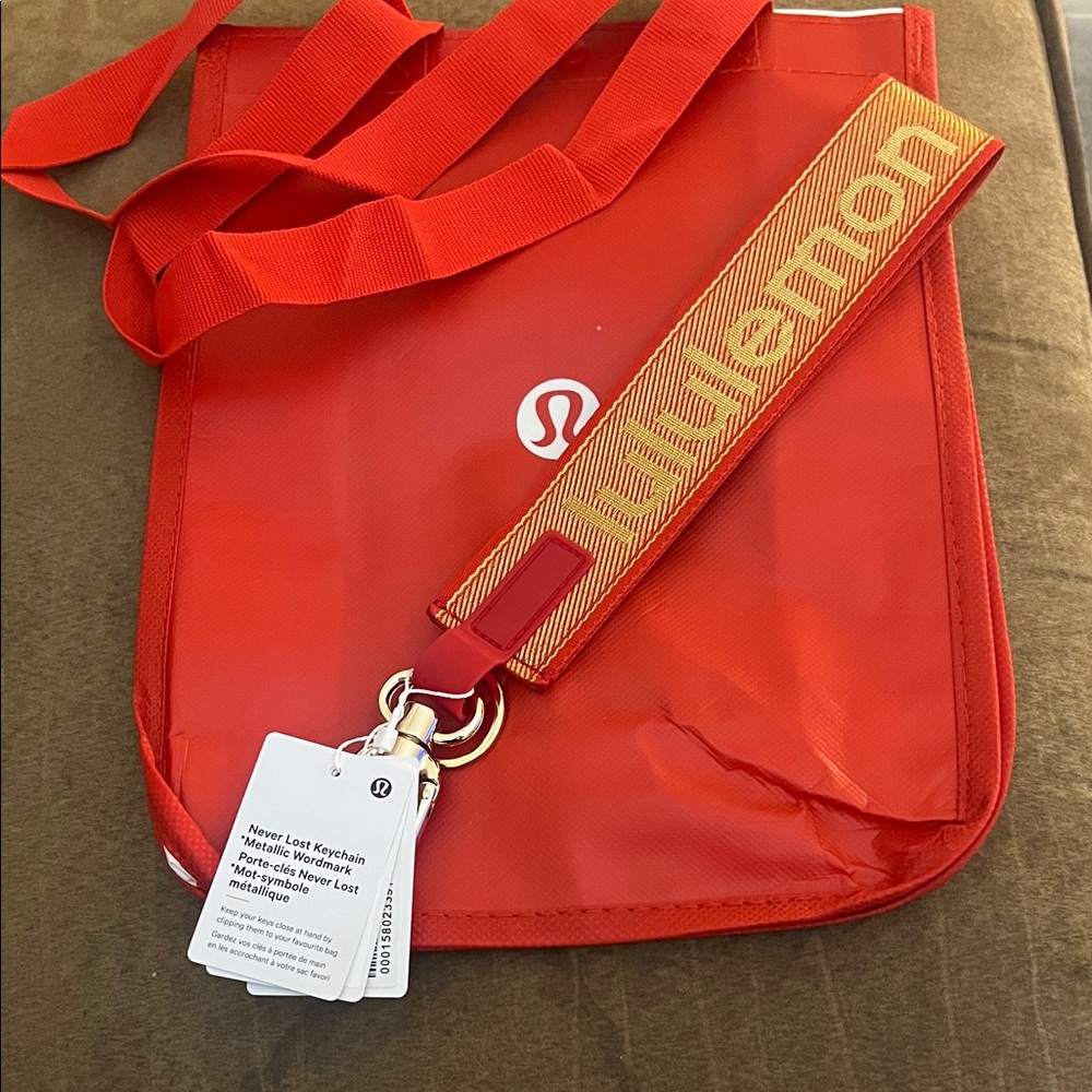 Lululemon Athletica Vibrant Red and Gold never lost keychain and tote